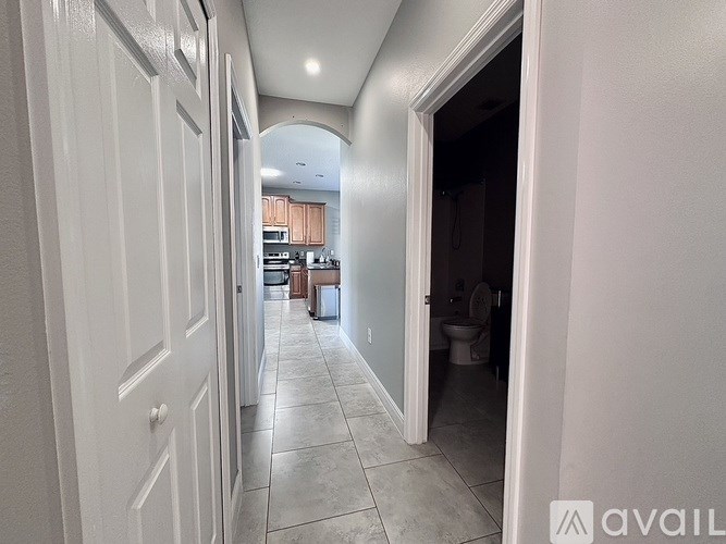 A hallway with a doorway leading to a bathroom.