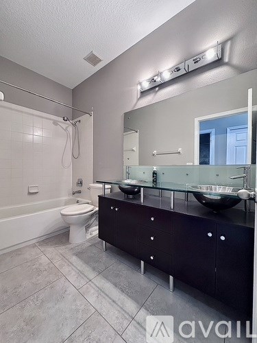 A bathroom with a toilet, sink, and mirror.