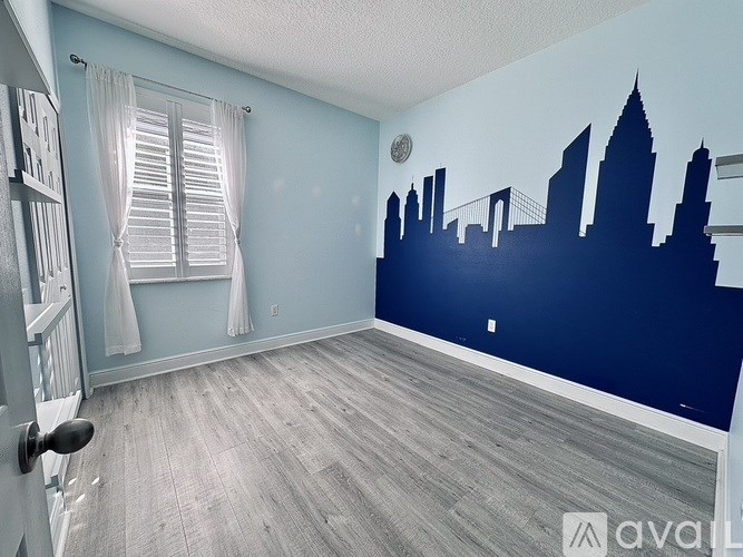 A room with a city skyline mural on the wall.