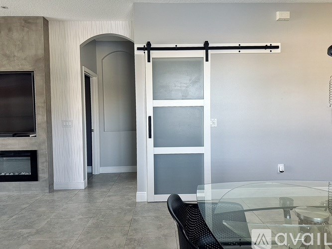 A glass table is in a room with a sliding door.