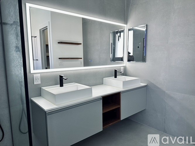 A bathroom vanity with two sinks and a large mirror.
