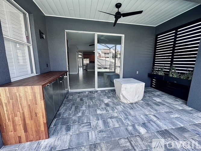 A room with a ceiling fan and a wooden cabinet.