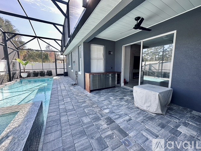 A patio with a pool and a ceiling fan.