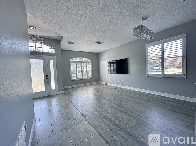 A spacious room with grey walls and wooden flooring.