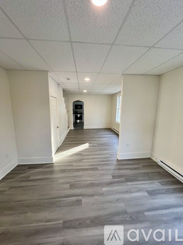 A room with wooden flooring and white walls.