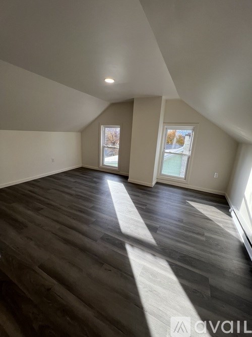 A room with wooden floors and a window letting in natural light.