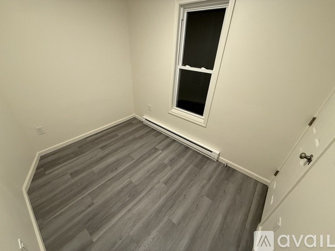 A room with a window and wooden flooring.