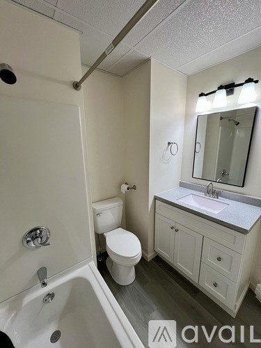 A bathroom with a toilet, sink, and bathtub.