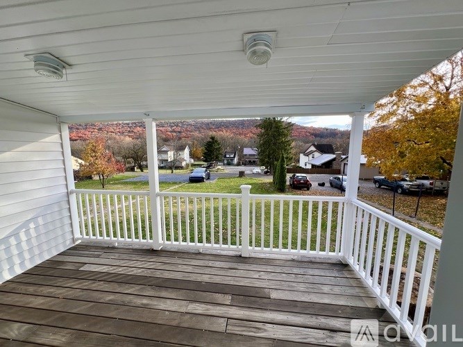 A white deck with a view of a neighborhood.