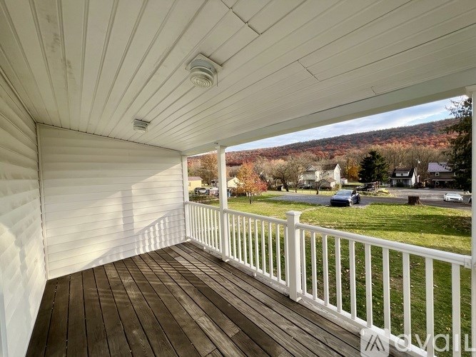 A white balcony with a view of a residential area.