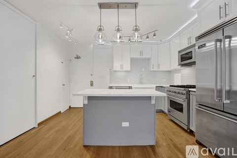 A modern kitchen with stainless steel appliances and wooden floors.