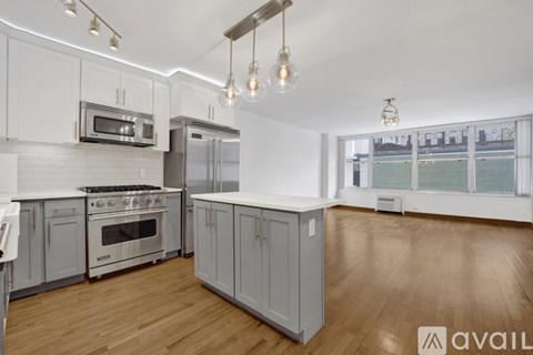 A kitchen with wooden floors and white cabinets.