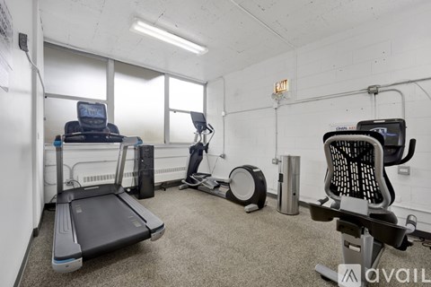 A gym room with a treadmill, exercise bike, and weights.