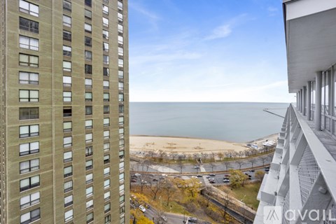 A tall building with a balcony overlooking a beach.