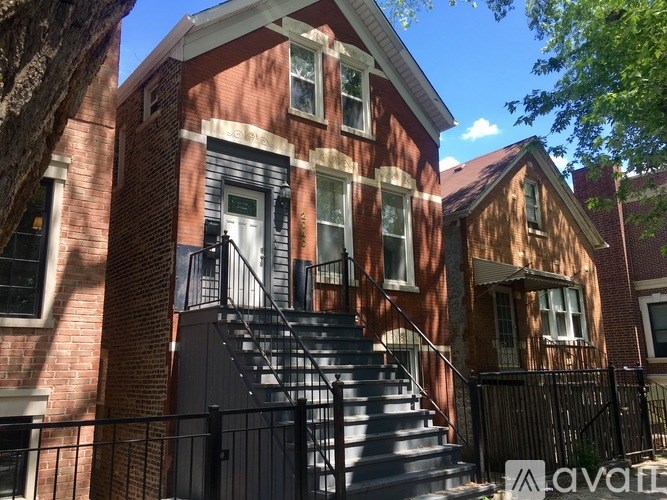 A red brick house with a black metal staircase.