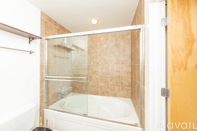 A bathroom with a white tub and a shower with a glass door.