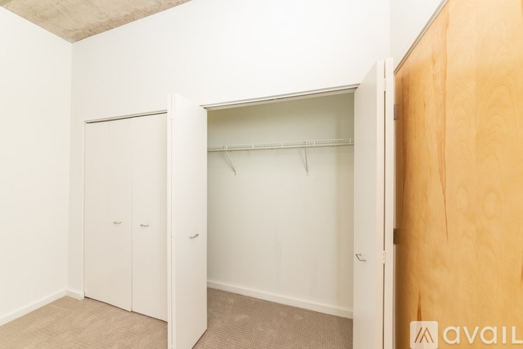 A room with a white wall and a wooden door.