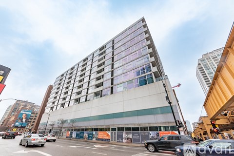 A modern building with a glass facade is under construction in an urban area.