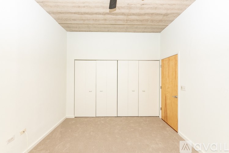 A room with a white wall and a brown door.