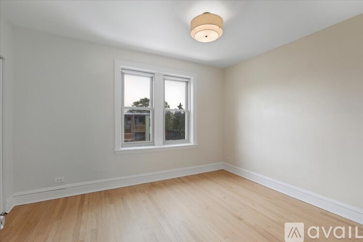 A room with a window and wooden flooring.