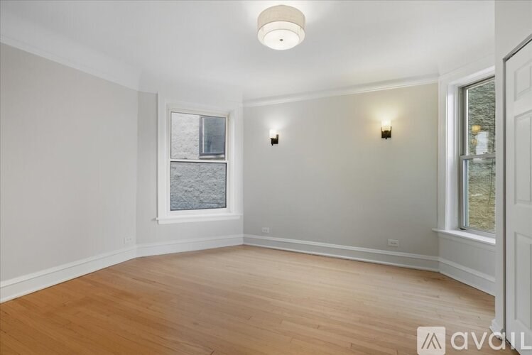 A room with wooden floors and a window showing a view of a body of water.