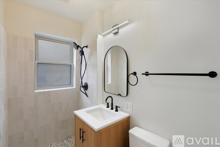 A bathroom with a sink, mirror, and shower.