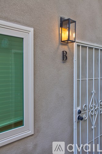 A white door with a glass window and a metal gate with a handle.