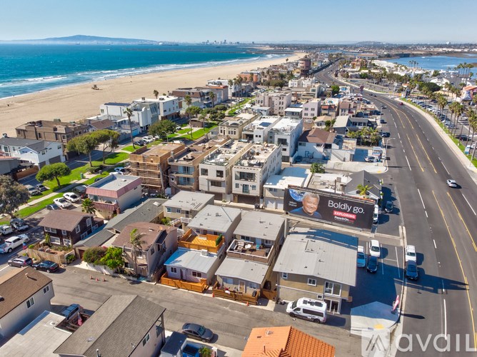A beachfront street with a billboard that says "Boldly go.".