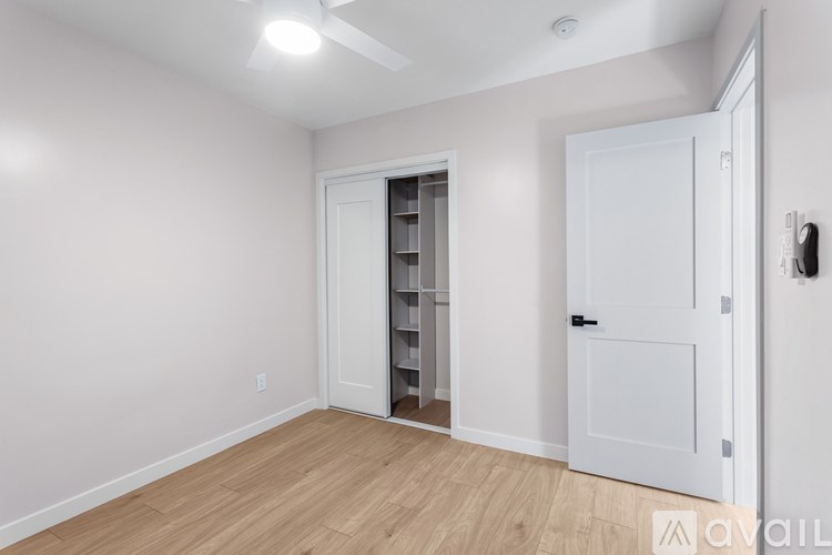 A room with a white door and a white cabinet with shelves.