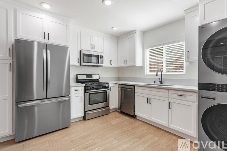 A modern kitchen with stainless steel appliances and white cabinets.