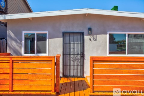 A house with a black gate and wooden fence.