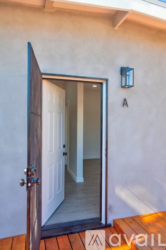 A wooden door with a glass window and a wall light.