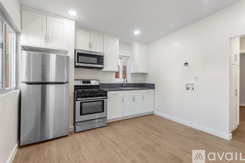 A modern kitchen with white cabinets and stainless steel appliances.