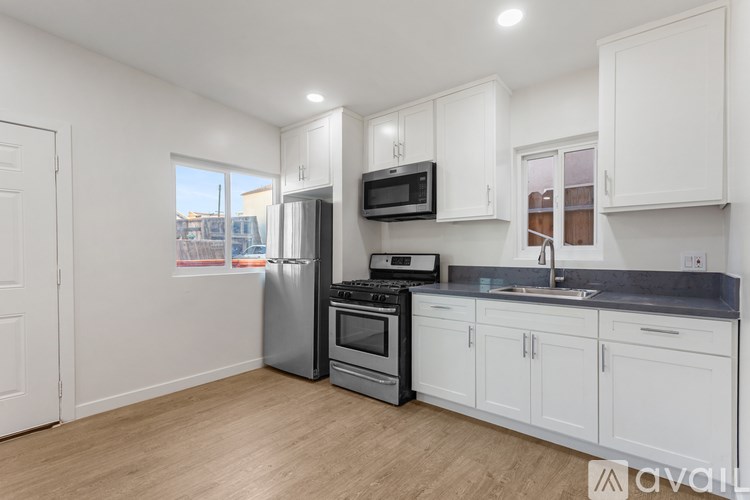 A kitchen with white cabinets and a stainless steel refrigerator.