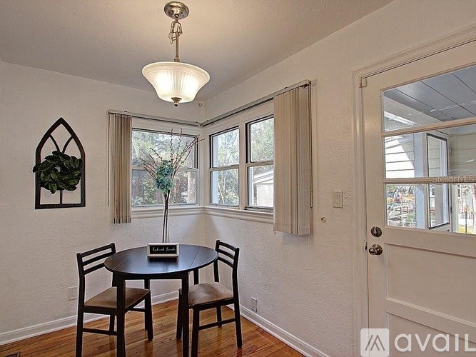 A dining room with a table and chairs.