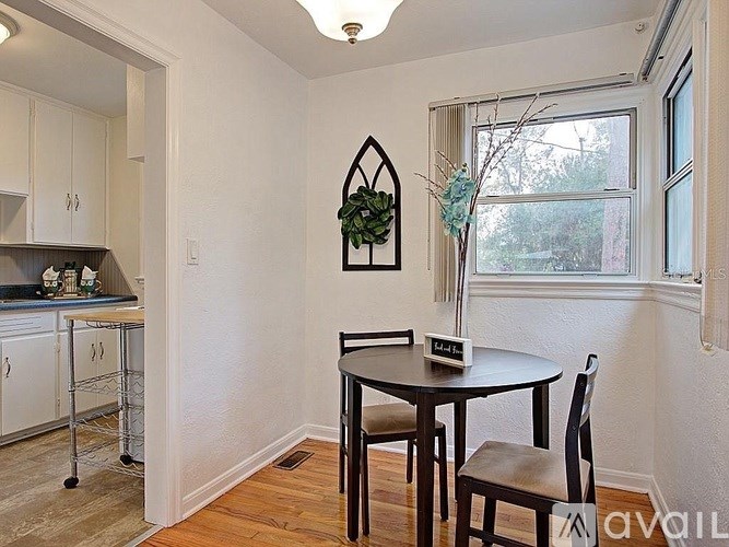 A dining room with a table and chairs.