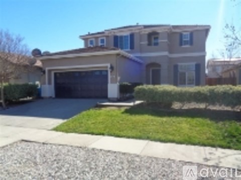 A two-story house with a garage and a driveway.