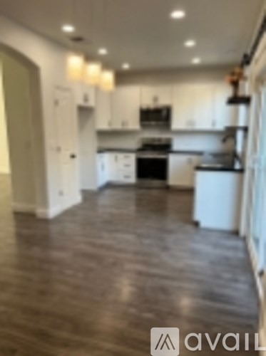 A kitchen with white cabinets and a black stove top oven.