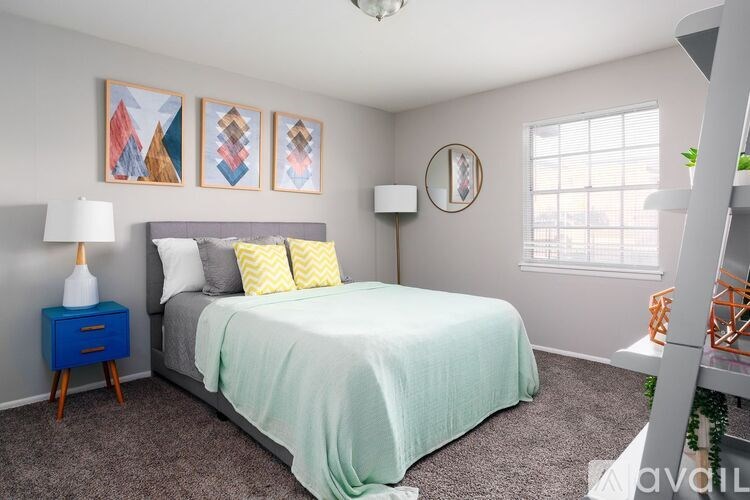 A bedroom with a bed, nightstand, and wall art.