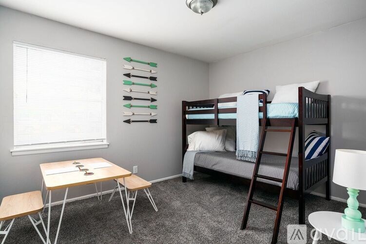 A room with a bunk bed, a desk, and a chair.