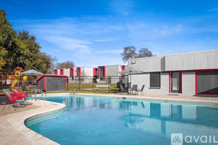A pool with a red chair and a building in the background.