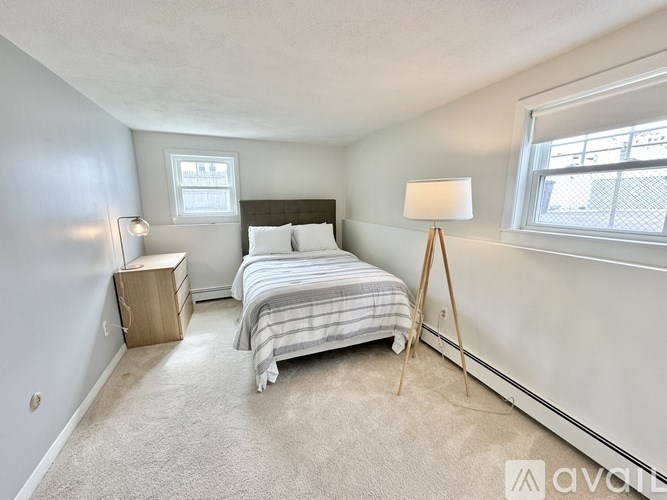 A bedroom with a bed, nightstand, and lamp.