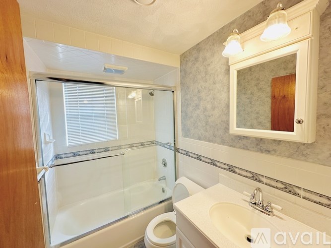 A bathroom with a toilet, sink, and shower.