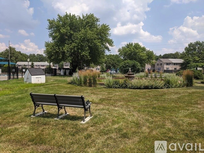 A park bench sits in the middle of a grassy field.