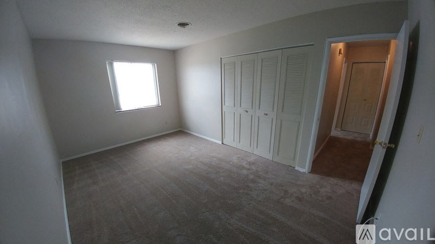 A room with a window and a door is available for rent.