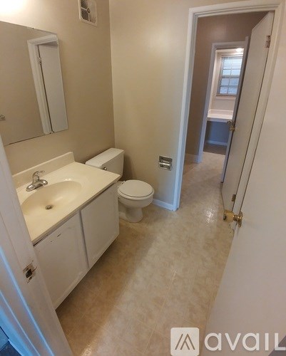 A bathroom with a sink, toilet and mirror.