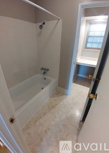 A bathroom with a tub and a window.