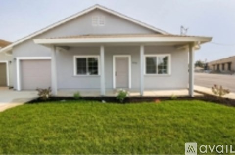 A house with a white exterior and a grey roof is shown.