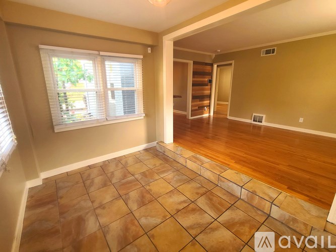 A room with tile flooring and a window with blinds.