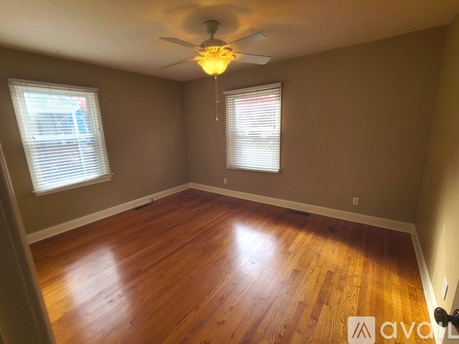 A room with wooden floors and a ceiling fan.